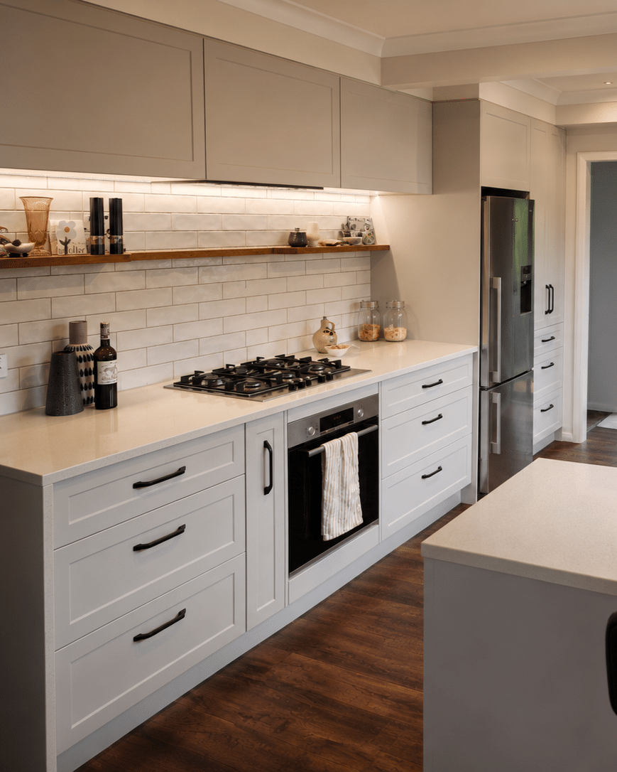 White Shaker kitchen with timber floating shelf, gas cooktop and island bench — The Garden Kitchen by Zander Edward