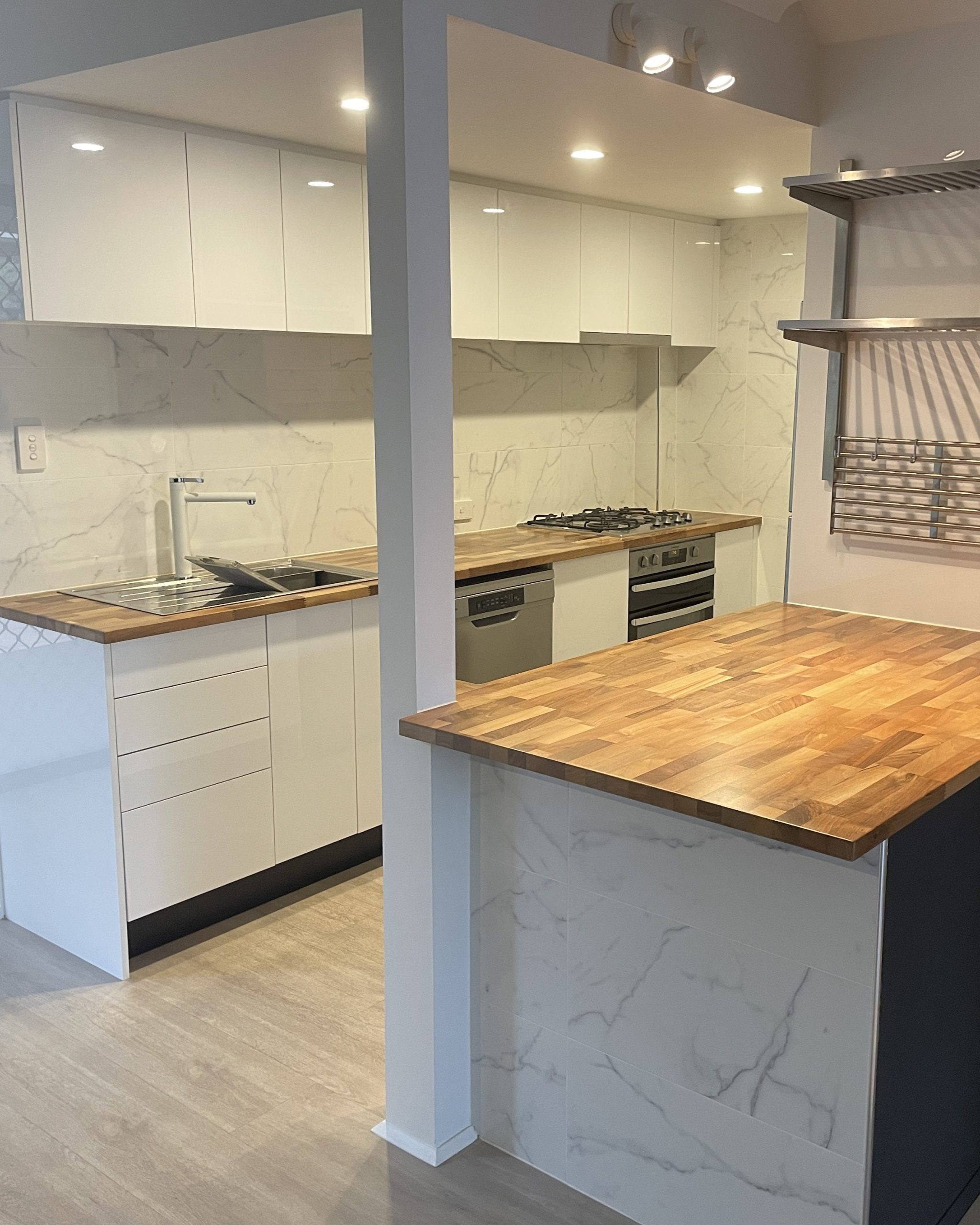 Townhouse kitchen renovation with clever storage, clean white cabinetry and warm natural timber finishes — Brisbane kitchen design by Zander Edward
